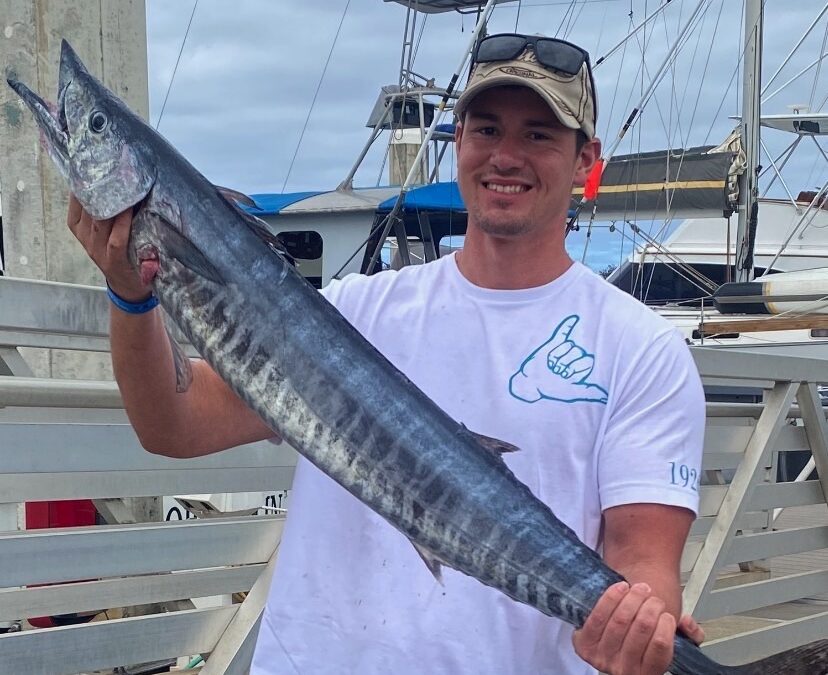 Deep sea fishing adventure with Hawaii Ocean Adventure Tours, showcasing anglers on a boat in the open ocean, ready for a big catch."
